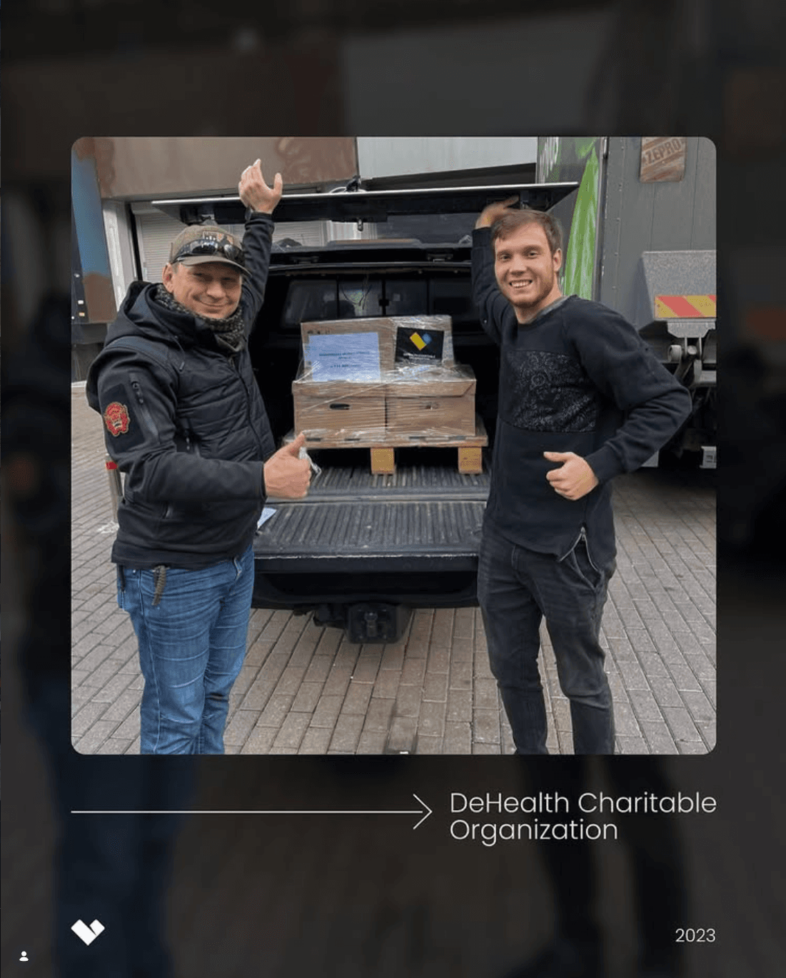 Двоє чоловіків біля транспорту з вантажем медикаментів DeHealth Charitable Organization, готовим до доставки