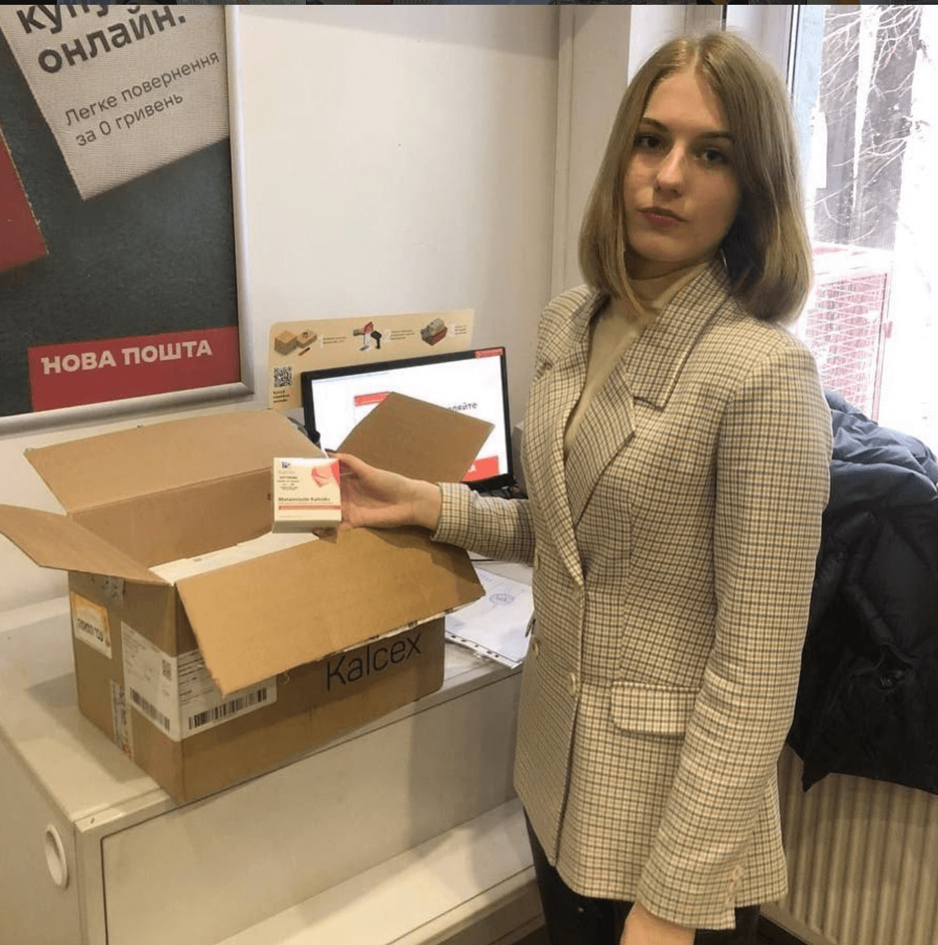 Партнерка ГО «Справедливість і чесність» з коробкою медикаментів від DeHealth у відділенні Нової Пошти